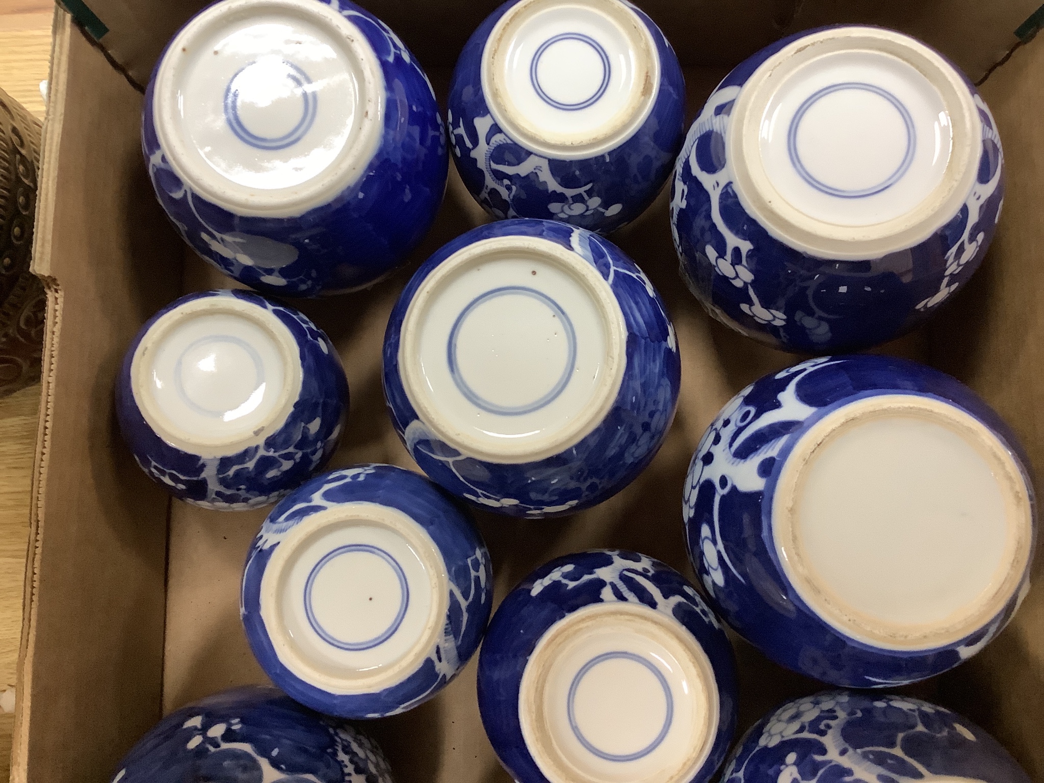 Fourteen Chinese blue and white 'prunus' jars, some with covers